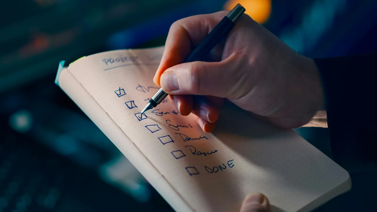 Main cochant une liste d'items au crayon : symbole audit Qualiopi RNQ V8 et traçabilité des 22 indicateurs.